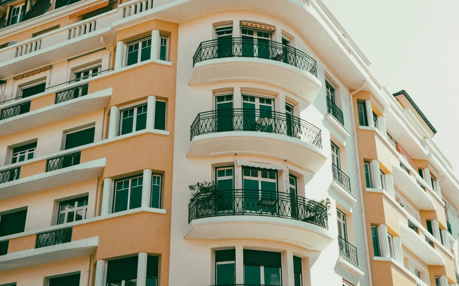 Kavisli balkonlu turuncu bir apartman cephesi