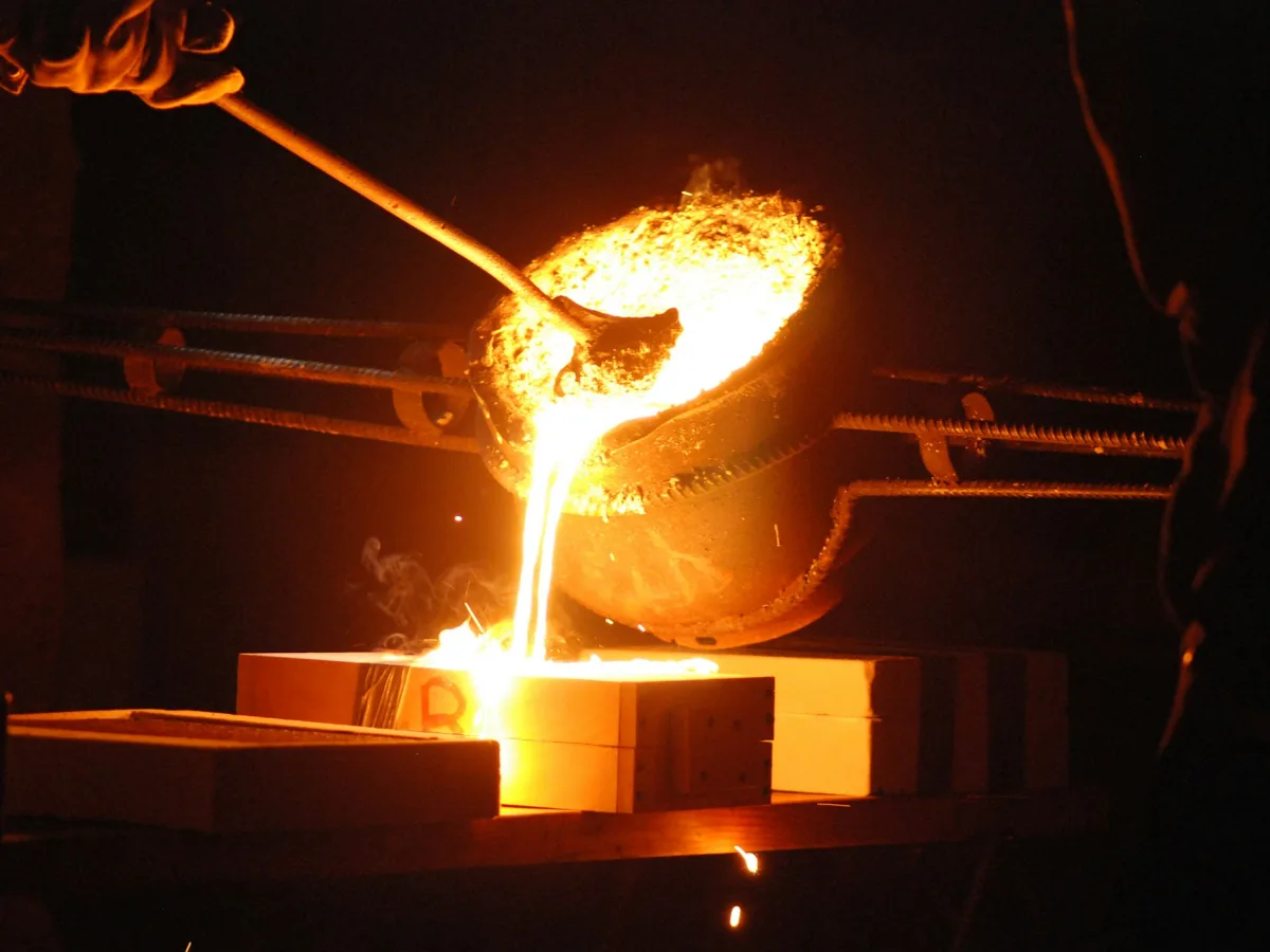Kepçeden kalıba ergimiş metal dökülen atölye anı