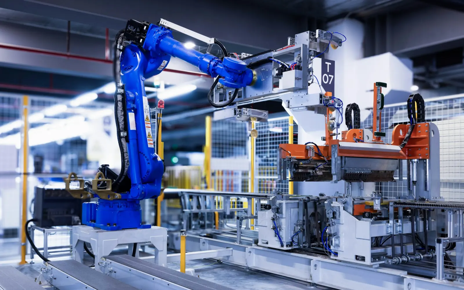 Mavi robot kolların çalıştığı otomasyonlu üretim hattı